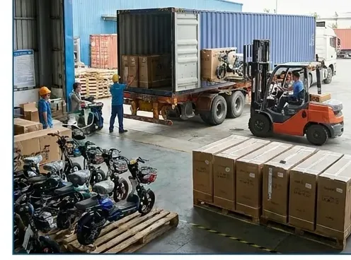 Starland staff loading packed vehicles and crates into a container truck
